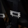Sim racing harness – rear shoulder strap adjusters Two harness shoulder straps and metal adjusters behind a racing seat